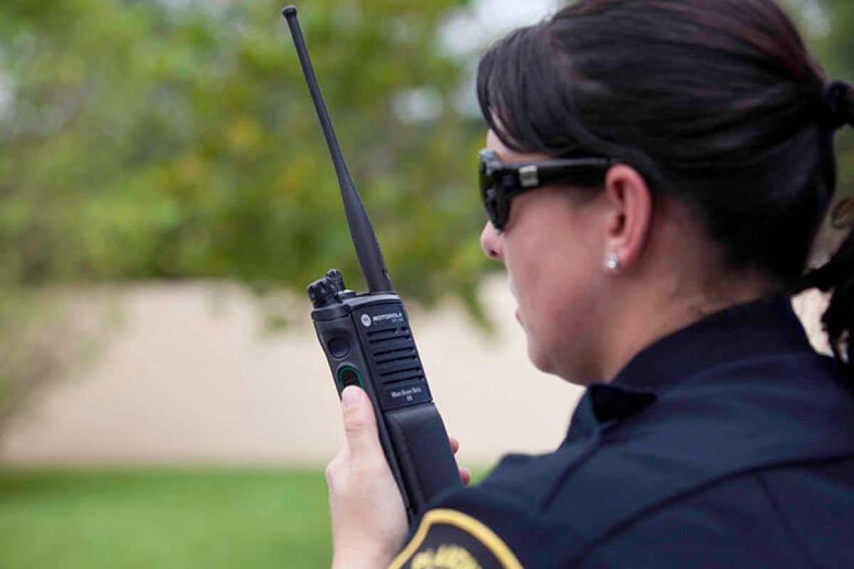 Person speaking into a GMRS radio outdoors